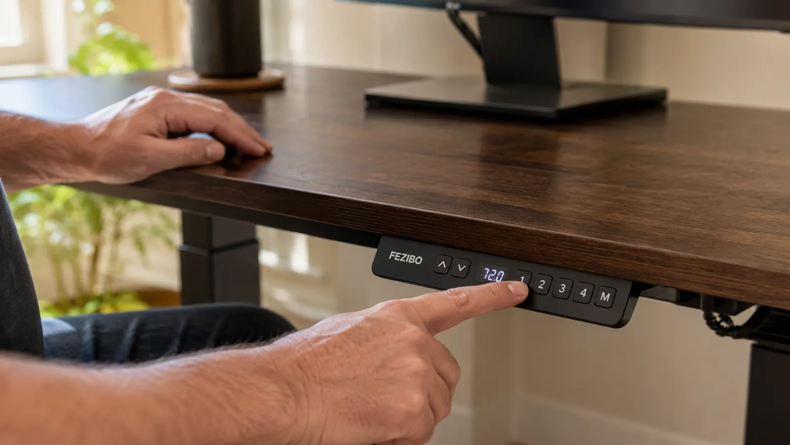 Hand pressing a memory height preset button on the standing desk control panel